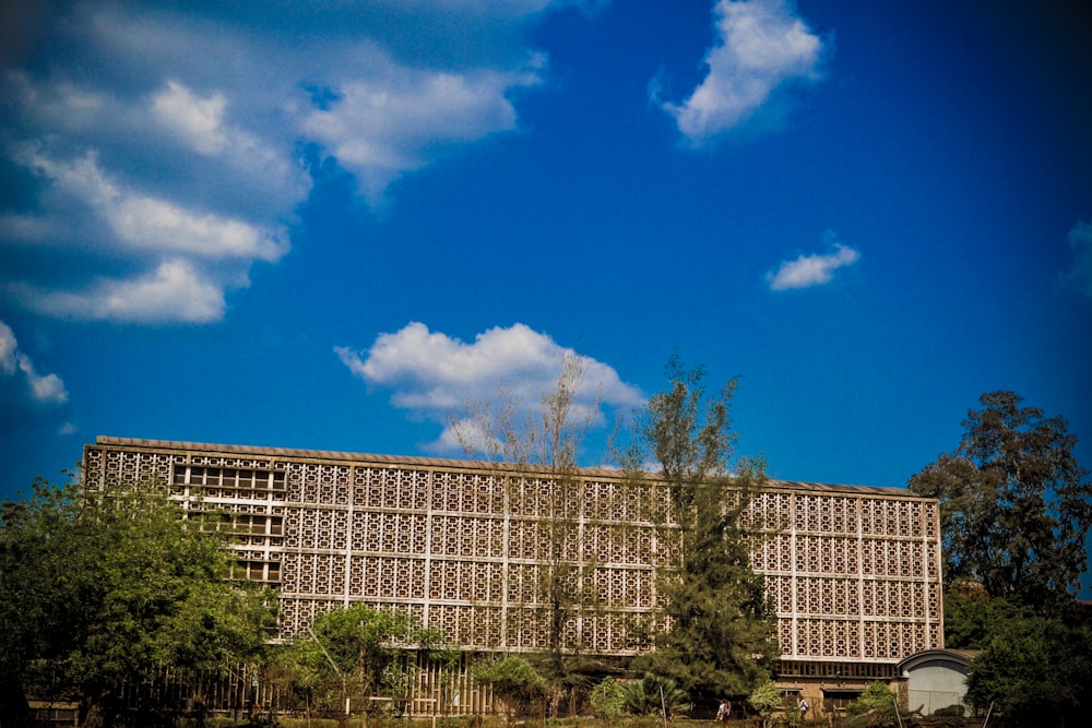 white concrete building near green trees under blue sky during daytime