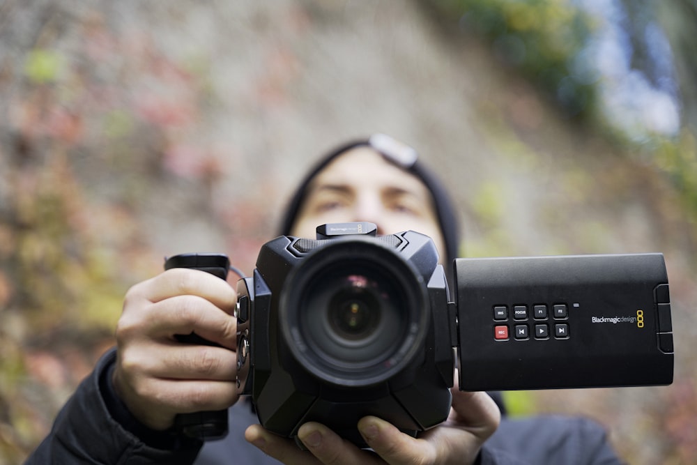 person holding black nikon dslr camera