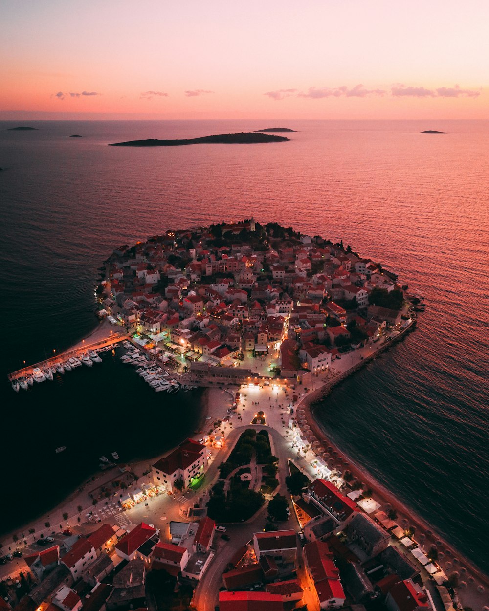 aerial view of city buildings near body of water during night time