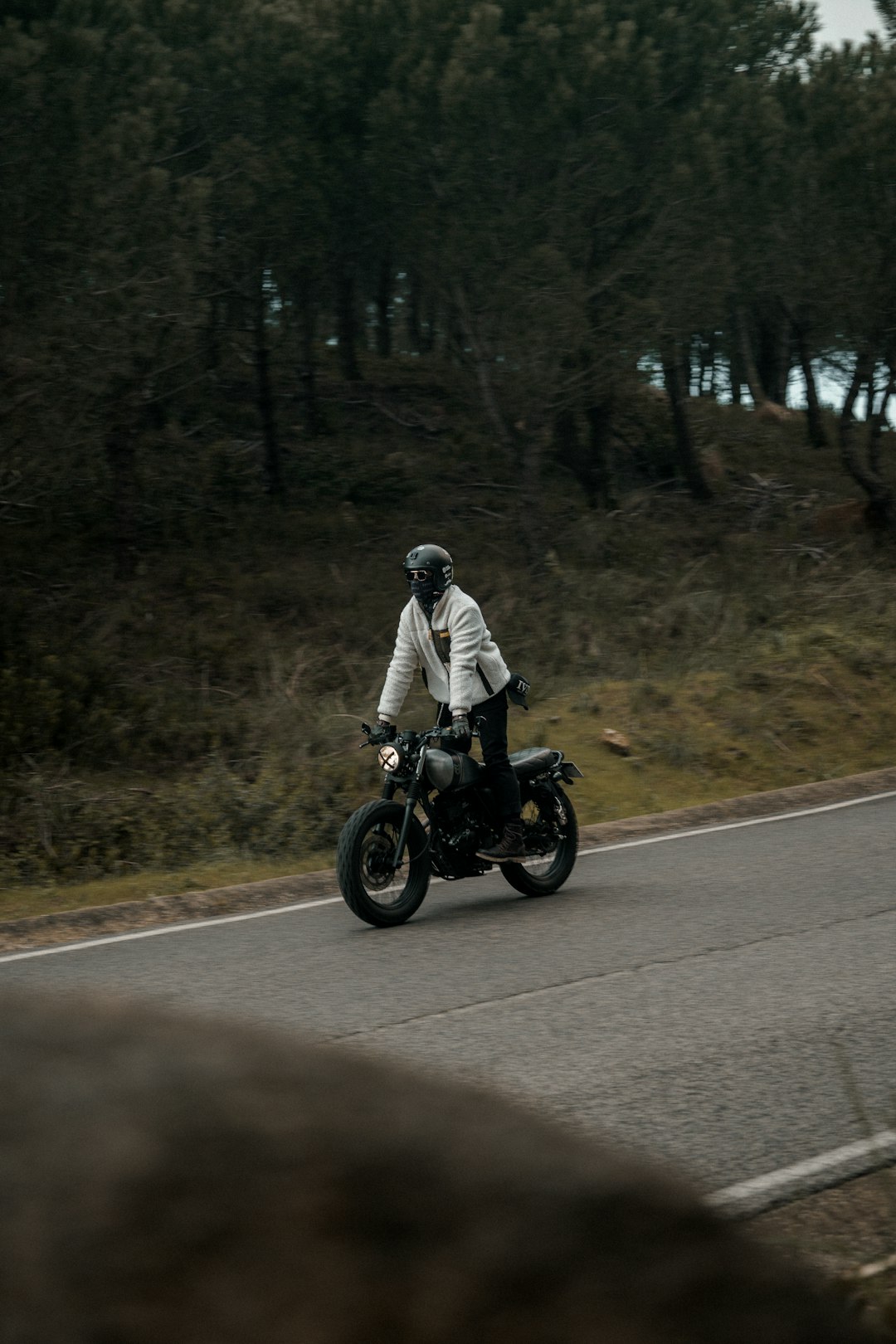 man in white jacket riding motorcycle on road during daytime