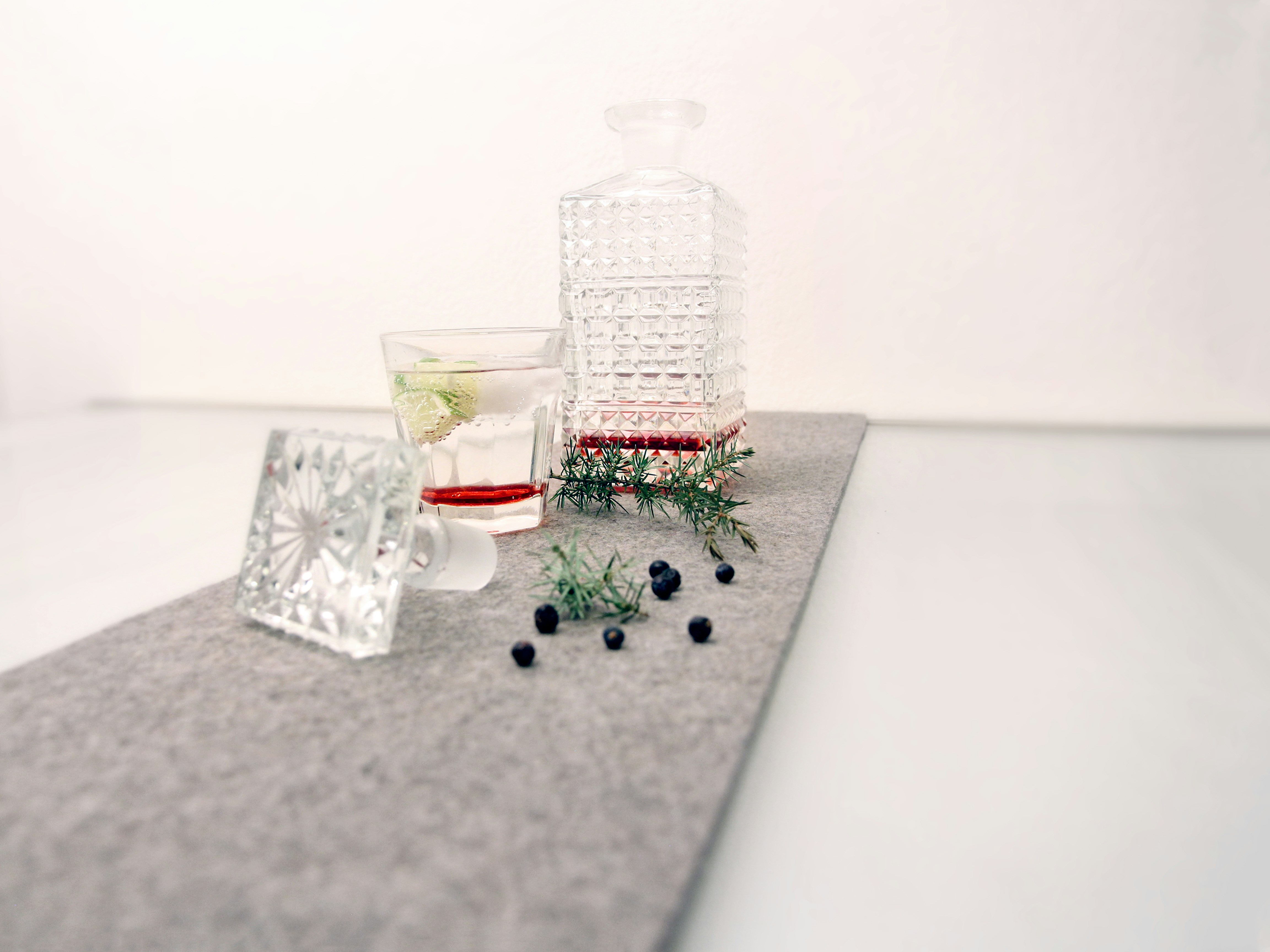 clear glass bottle with red liquid on white table