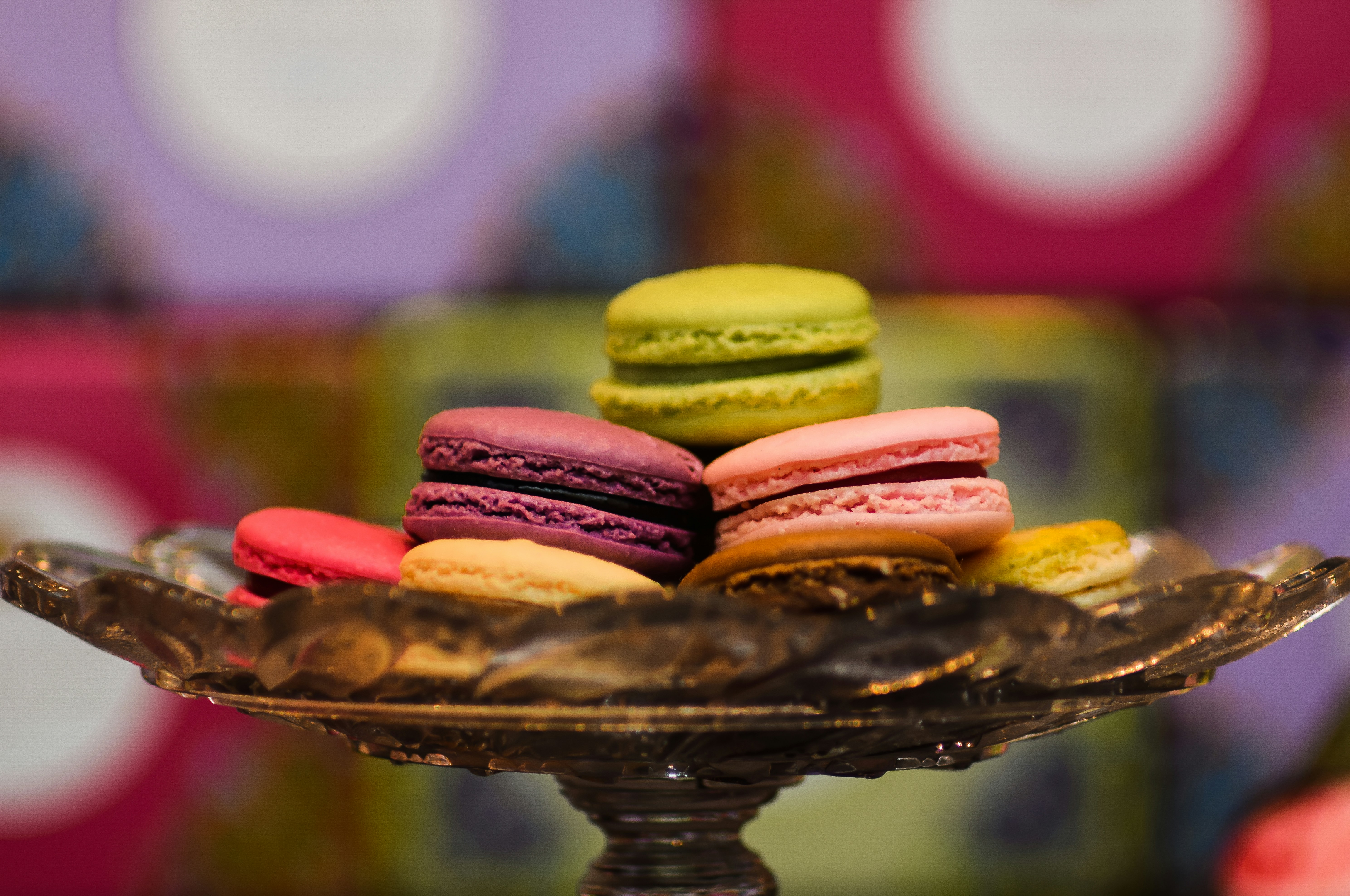 selective focus photography of cookies on black glass tray, Macaroons on a plate at a shop