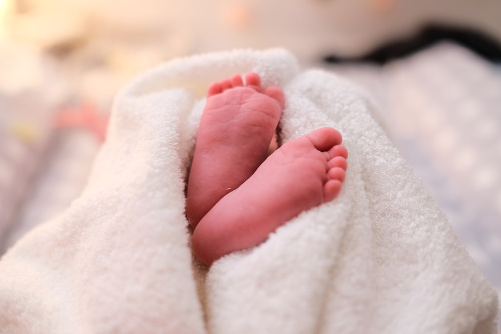bebé cubierto con manta blanca