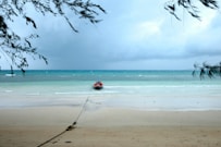 person in red shirt standing on beach during daytime