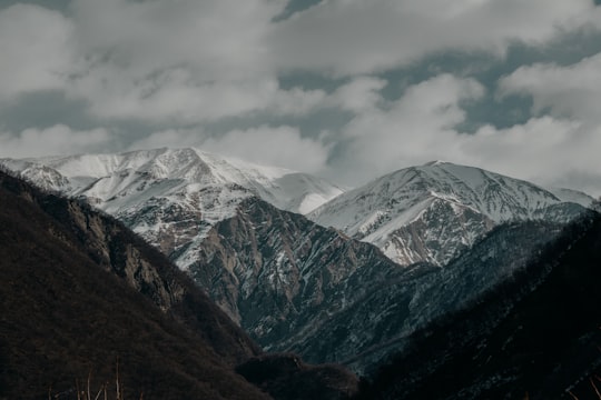 snow covered mountains under cloudy sky during daytime in Shaki Azerbaijan