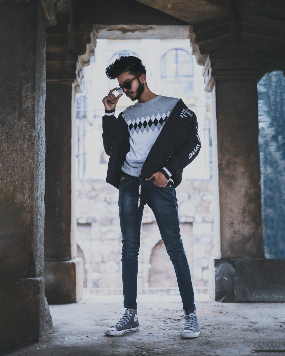 man in black jacket and black pants standing on gray concrete floor during daytime