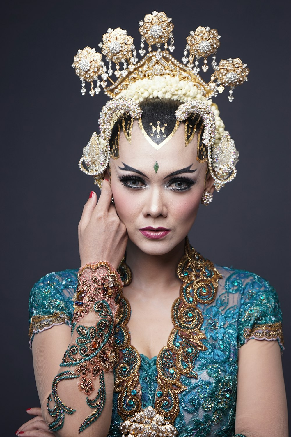 woman in blue and gold floral dress wearing gold crown