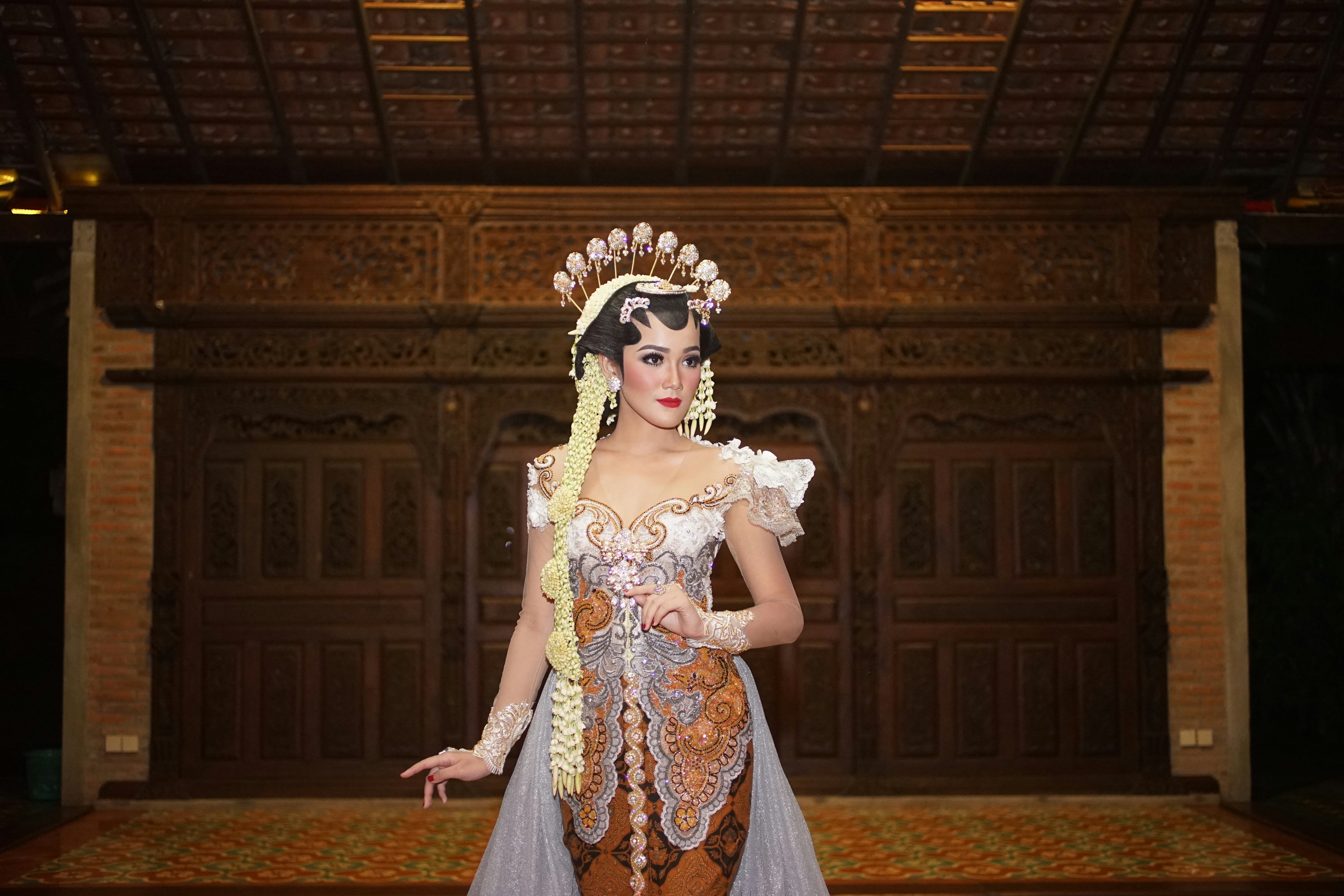 wanita dengan gaun bunga putih dan biru mengenakan mahkota putih dan emas