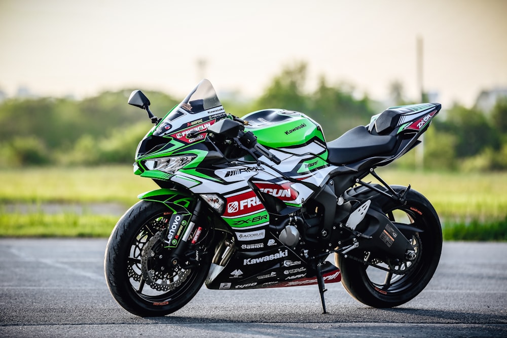 white and green sports bike on road during daytime