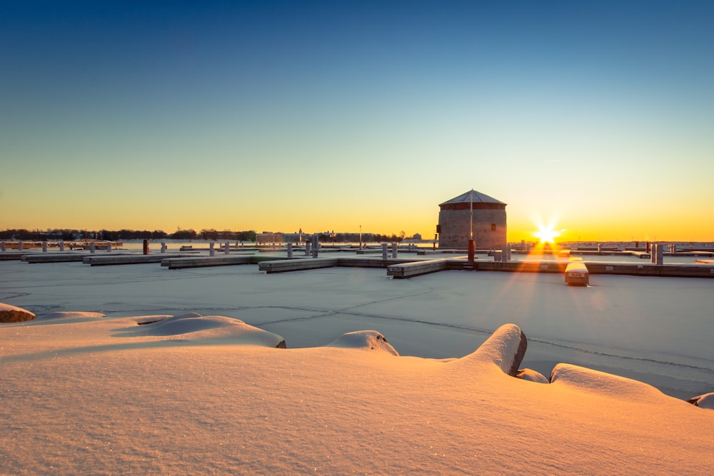 Braunes Holzhaus auf schneebedecktem Boden bei Sonnenuntergang