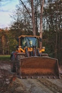 yellow and black tractor on green grass field during daytime