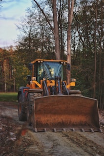 yellow and black tractor on green grass field during daytime