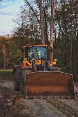 yellow and black tractor on green grass field during daytime