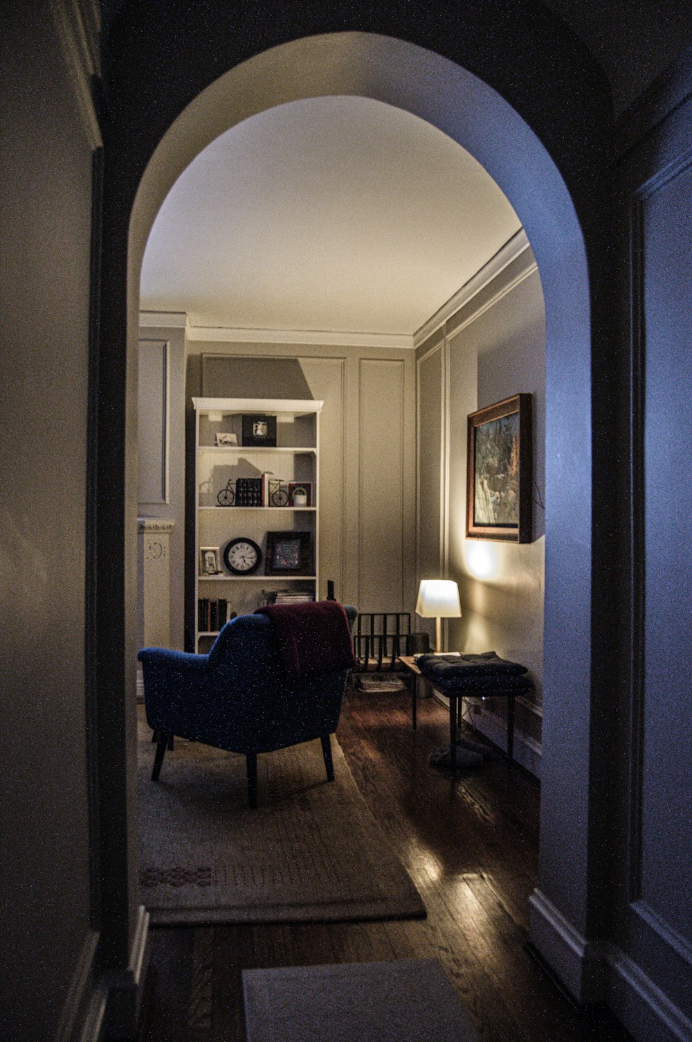 black wooden framed blue padded armchair beside brown wooden table