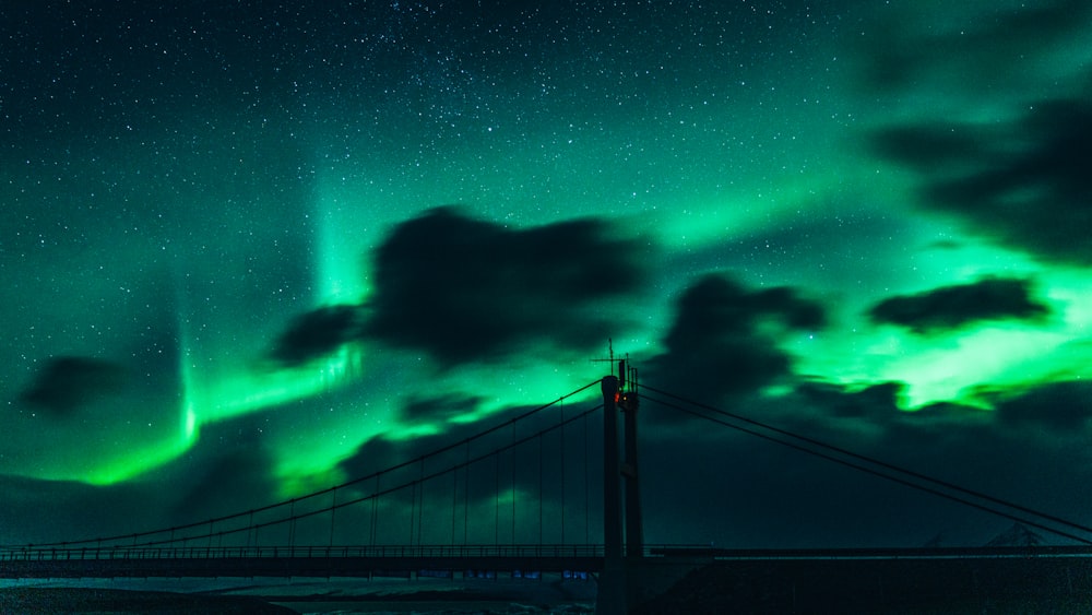 bridge under green sky with stars