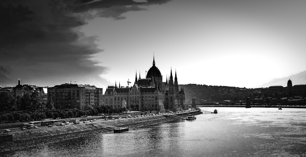 grayscale photo of building near body of water