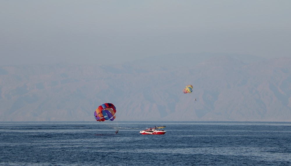 red and yellow parachute over the sea during daytime