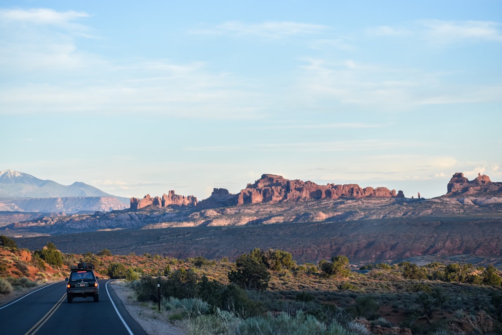 black asphalt road near brown mountains during daytime