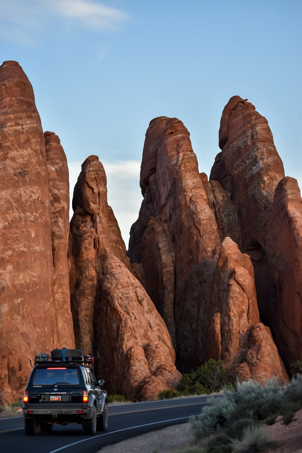 blue and black bus near brown rock formation during daytime