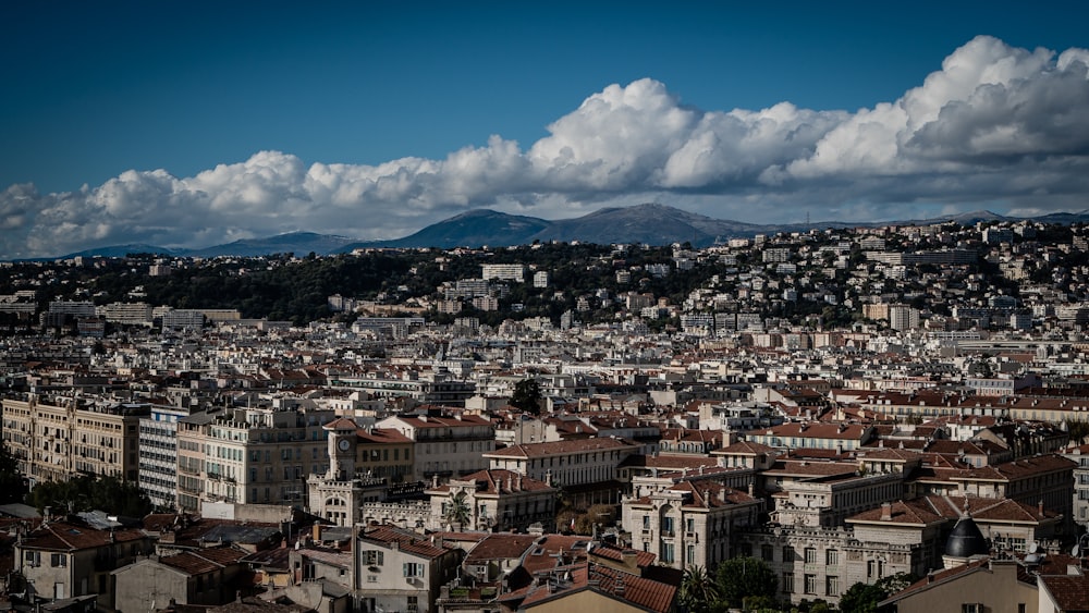 aerial view of city under blue sky and white clouds during daytime