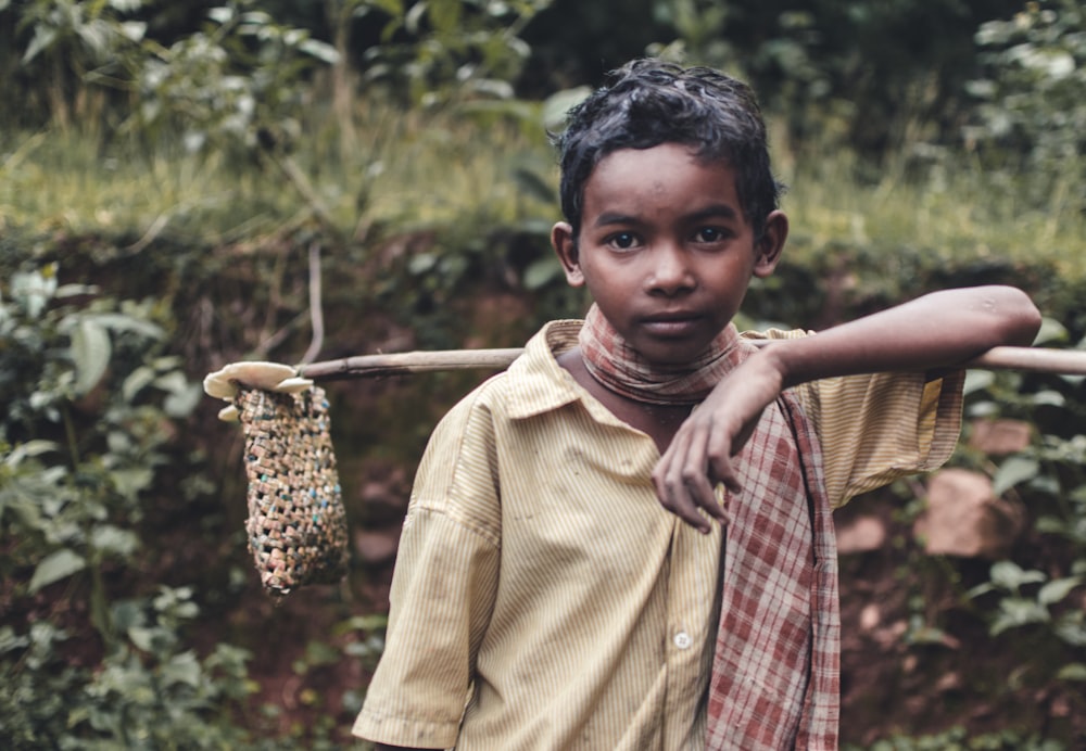 boy in yellow button up shirt holding brown woven basket