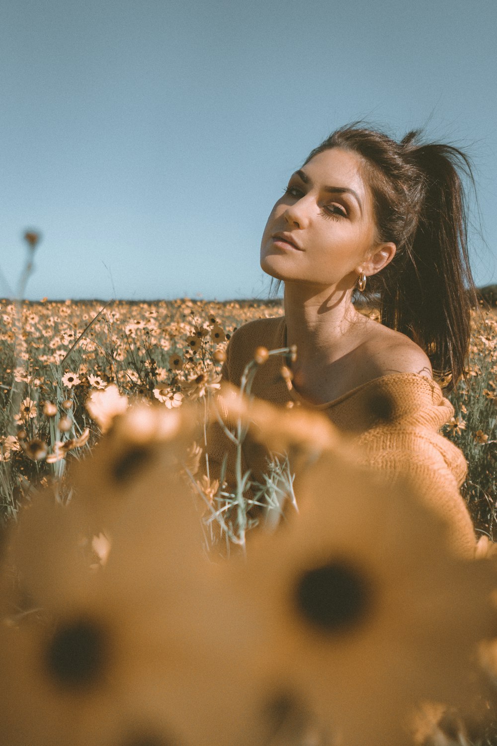 woman in brown shirt standing on brown grass field during daytime