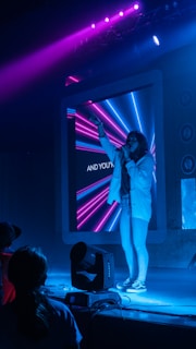 woman in white jacket standing on stage