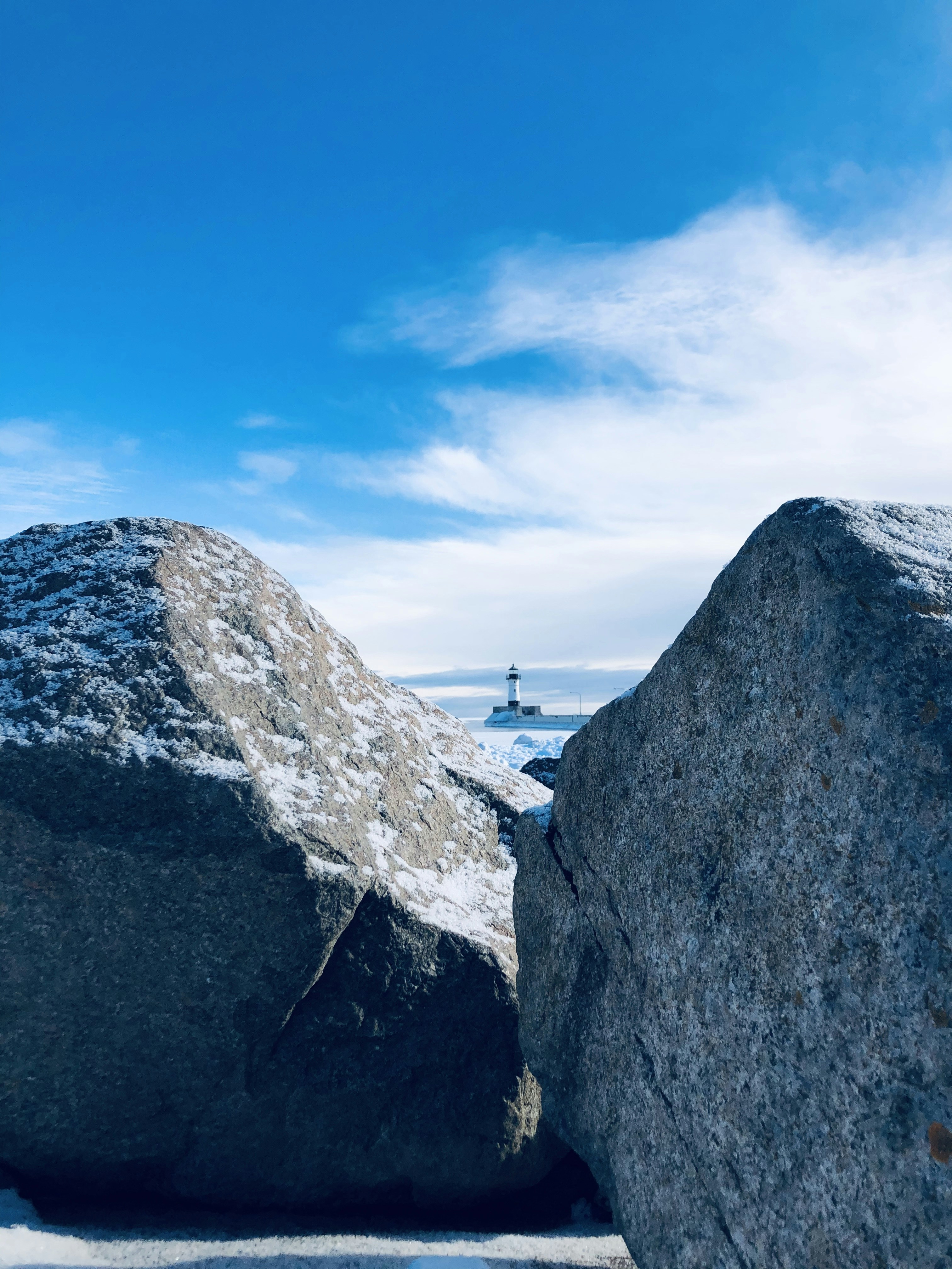 person standing on gray rock formation under blue sky during daytime