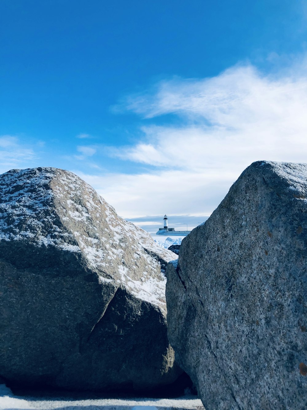 person standing on gray rock formation under blue sky during daytime