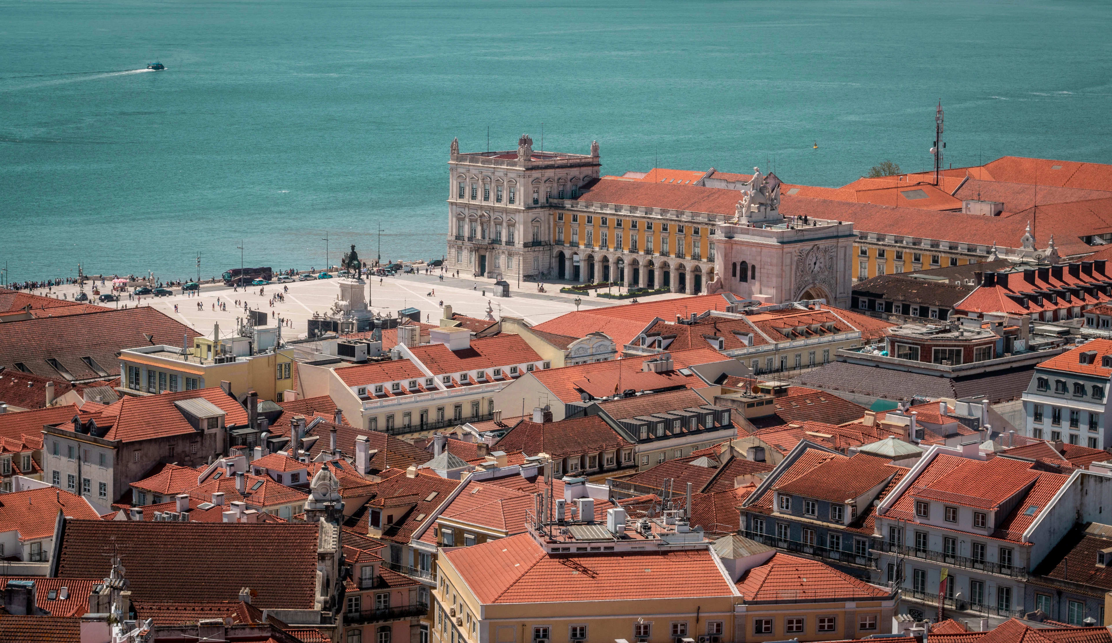 Aerial view over Lisbon's terracotta rooftops to Praça do Comércio and the Tagus river