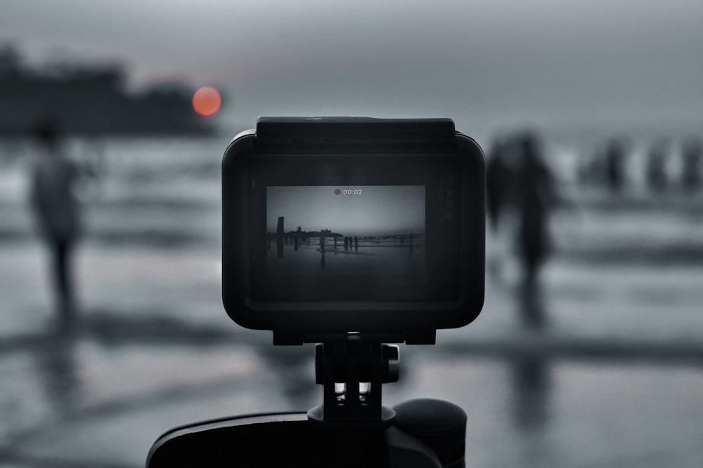 black camera taking photo of sea during daytime