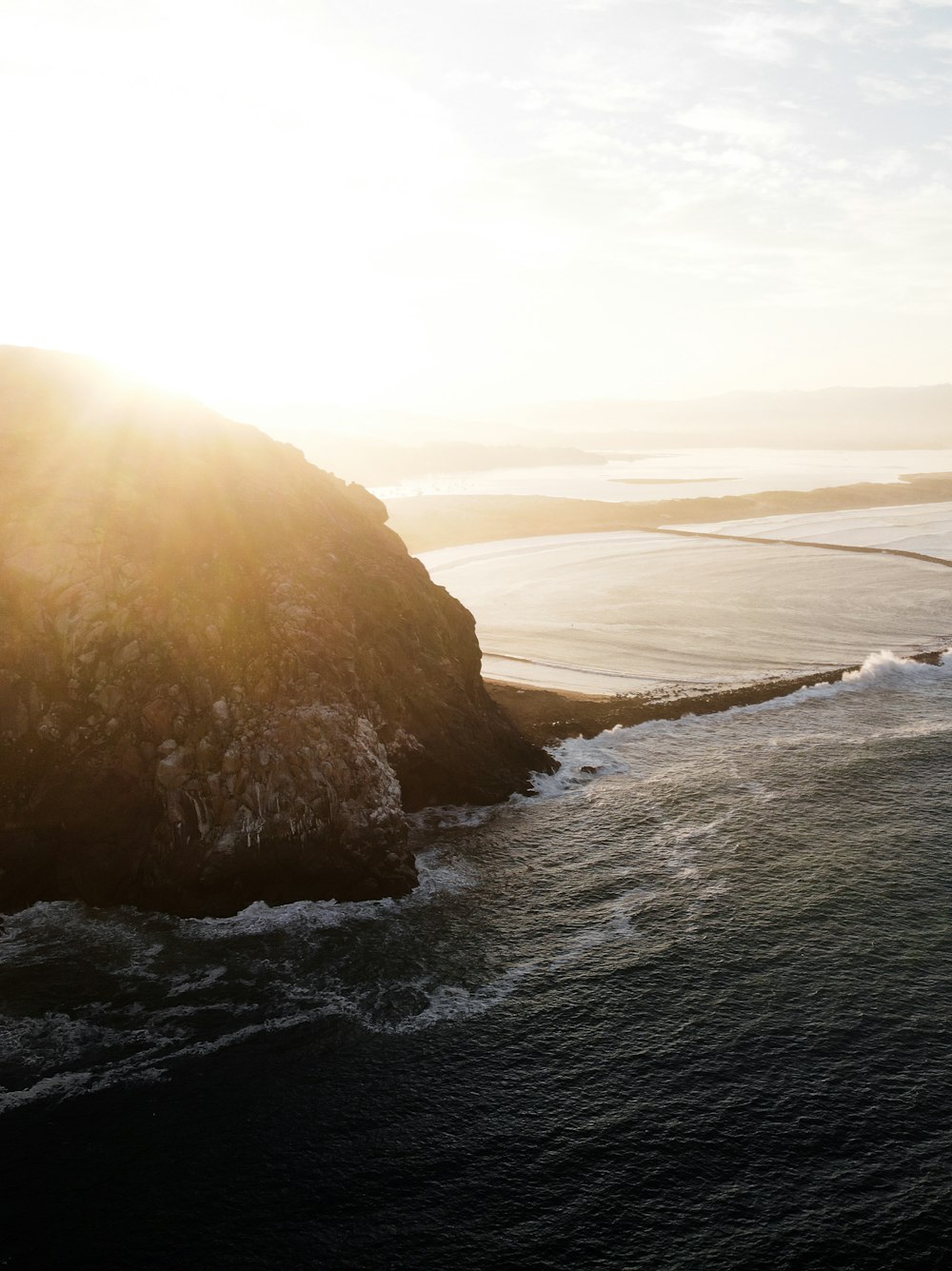 ocean waves crashing on rock formation during daytime