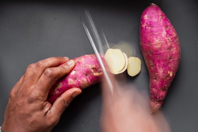 person holding pink and green watermelon sweet potato teams background