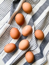 brown egg on white and blue stripe textile