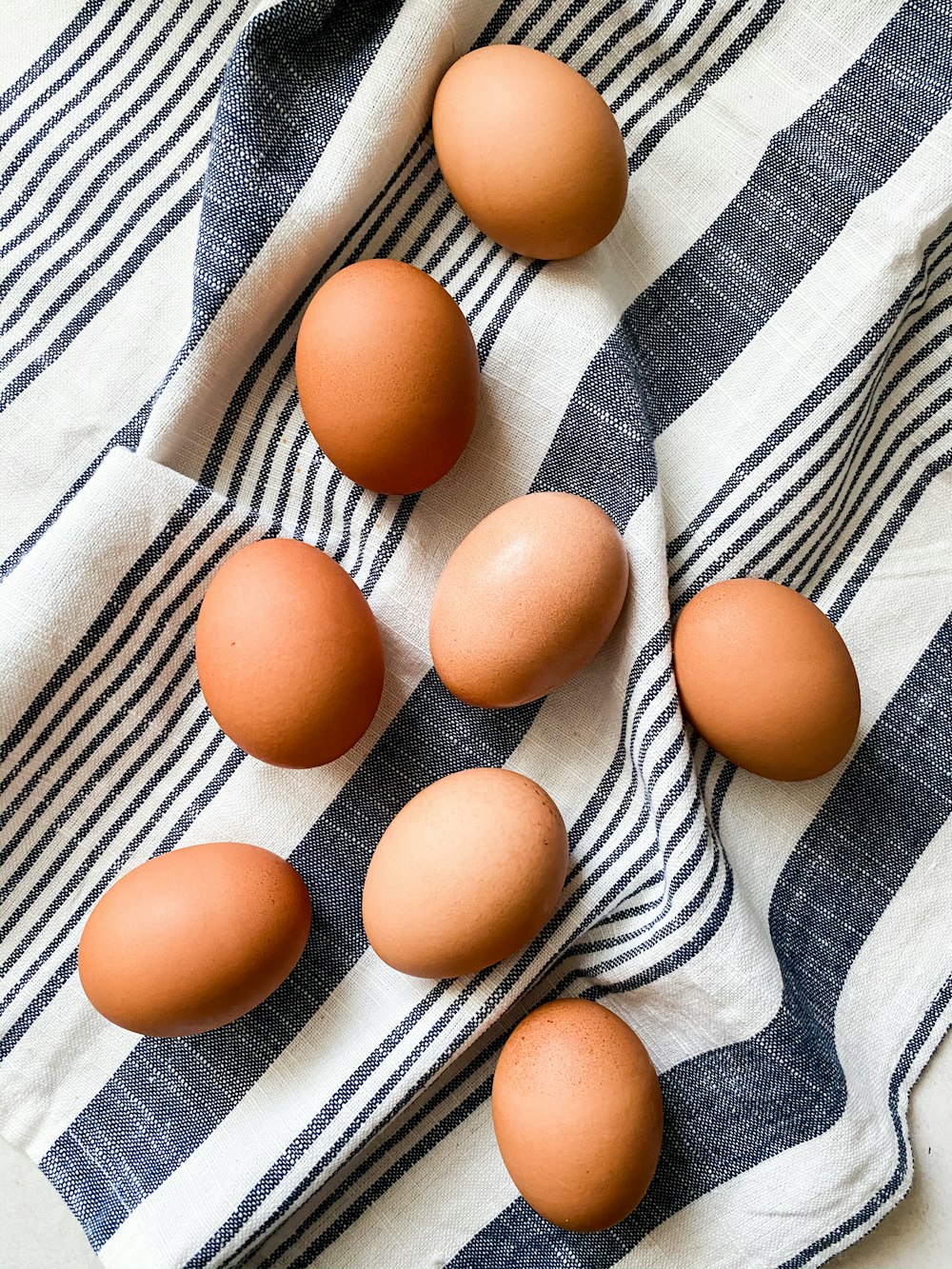 brown egg on white and blue stripe textile