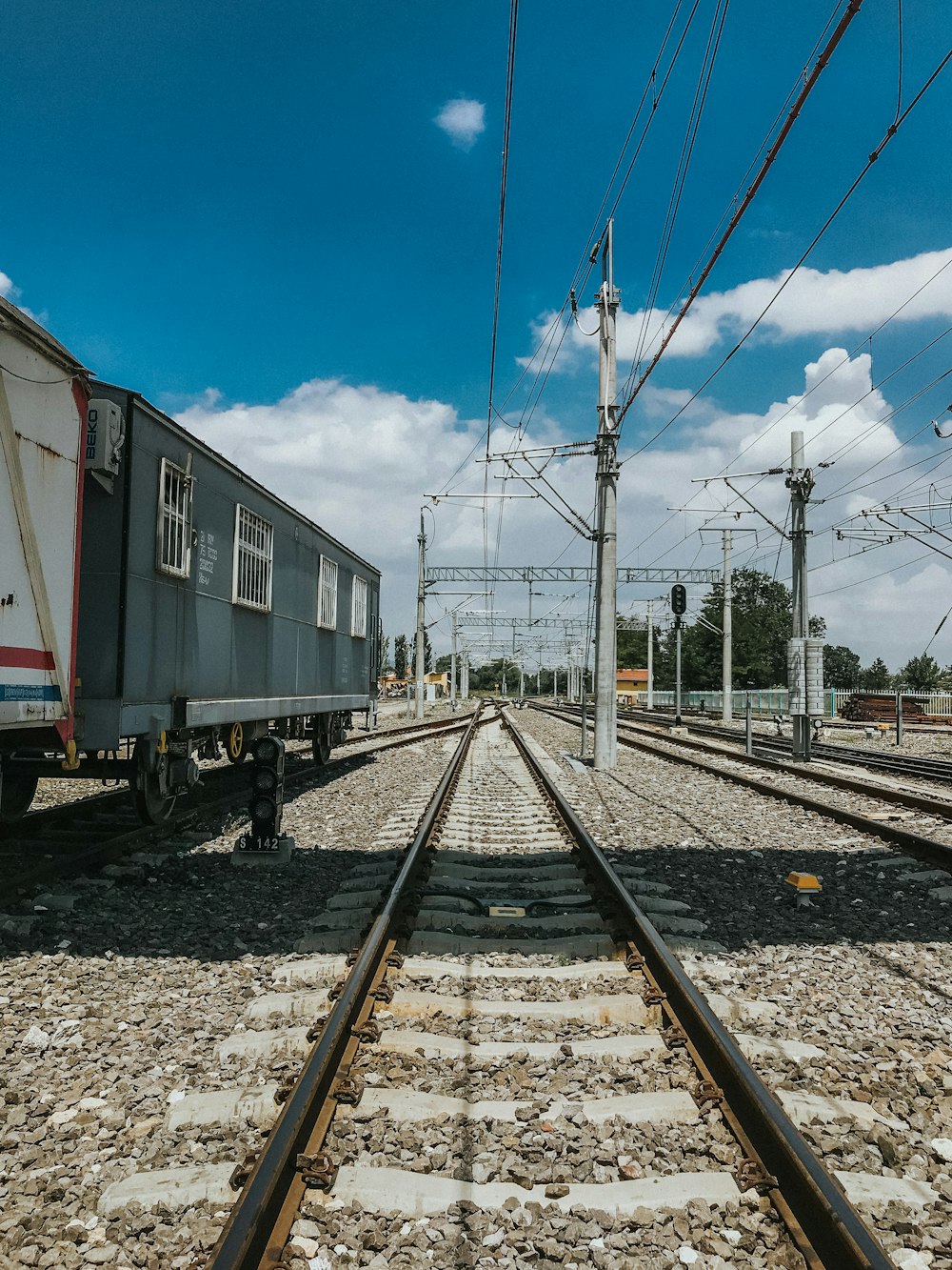 Tren blanco y rojo en las vías del tren bajo el cielo azul durante el día