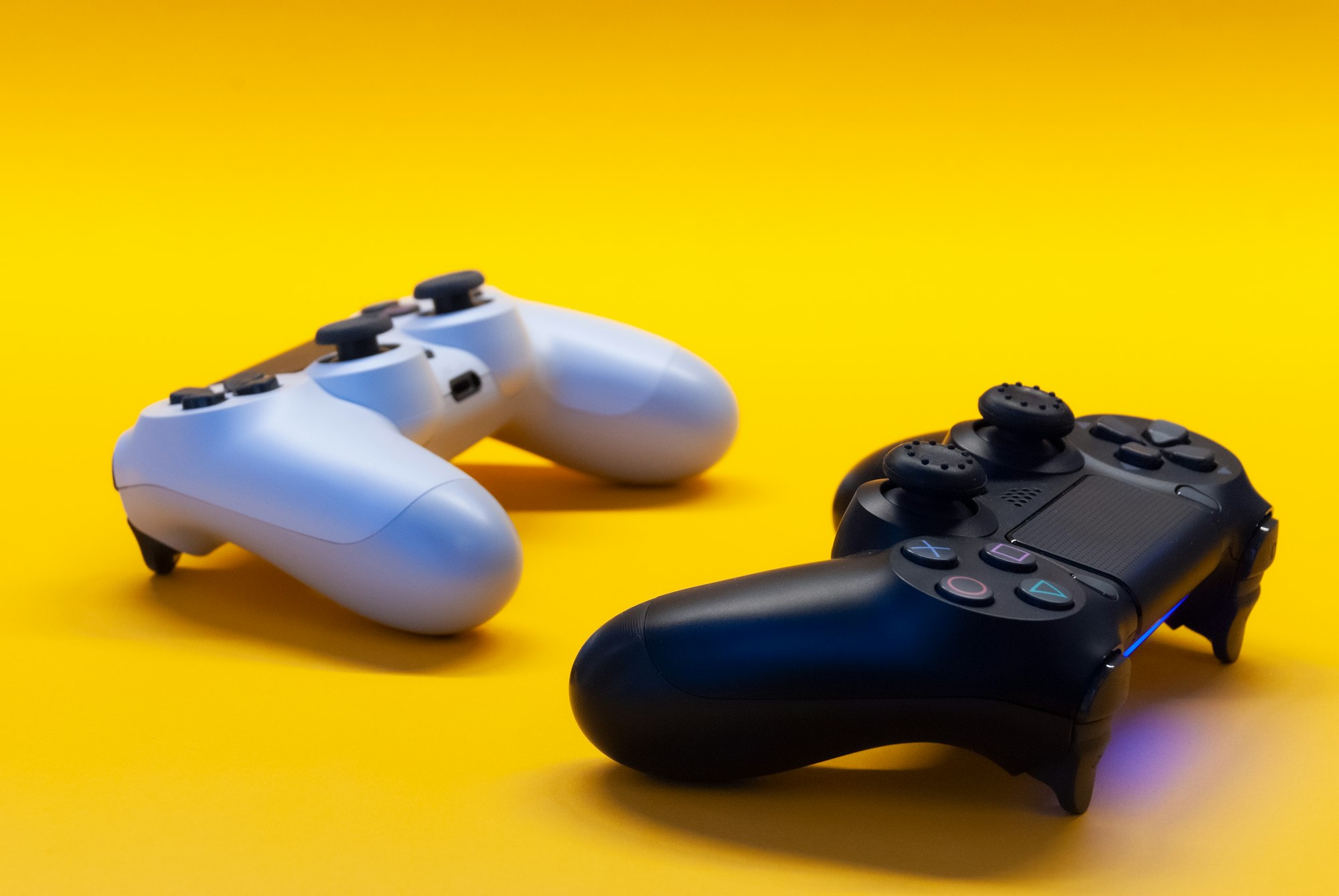 Black and white controllers on a  yellow background
