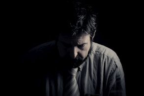 man i grå skjota med vit slips