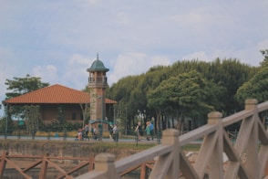 people walking on bridge near brown and white building during daytime