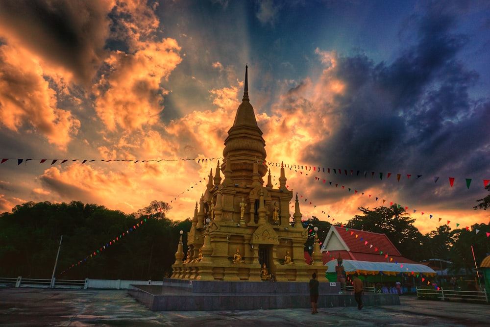 gold and black temple under cloudy sky