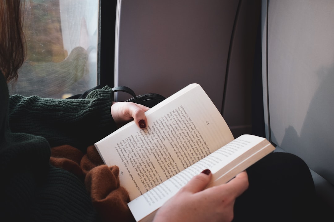 person holding white printer paper, Reading on a train to Bruge