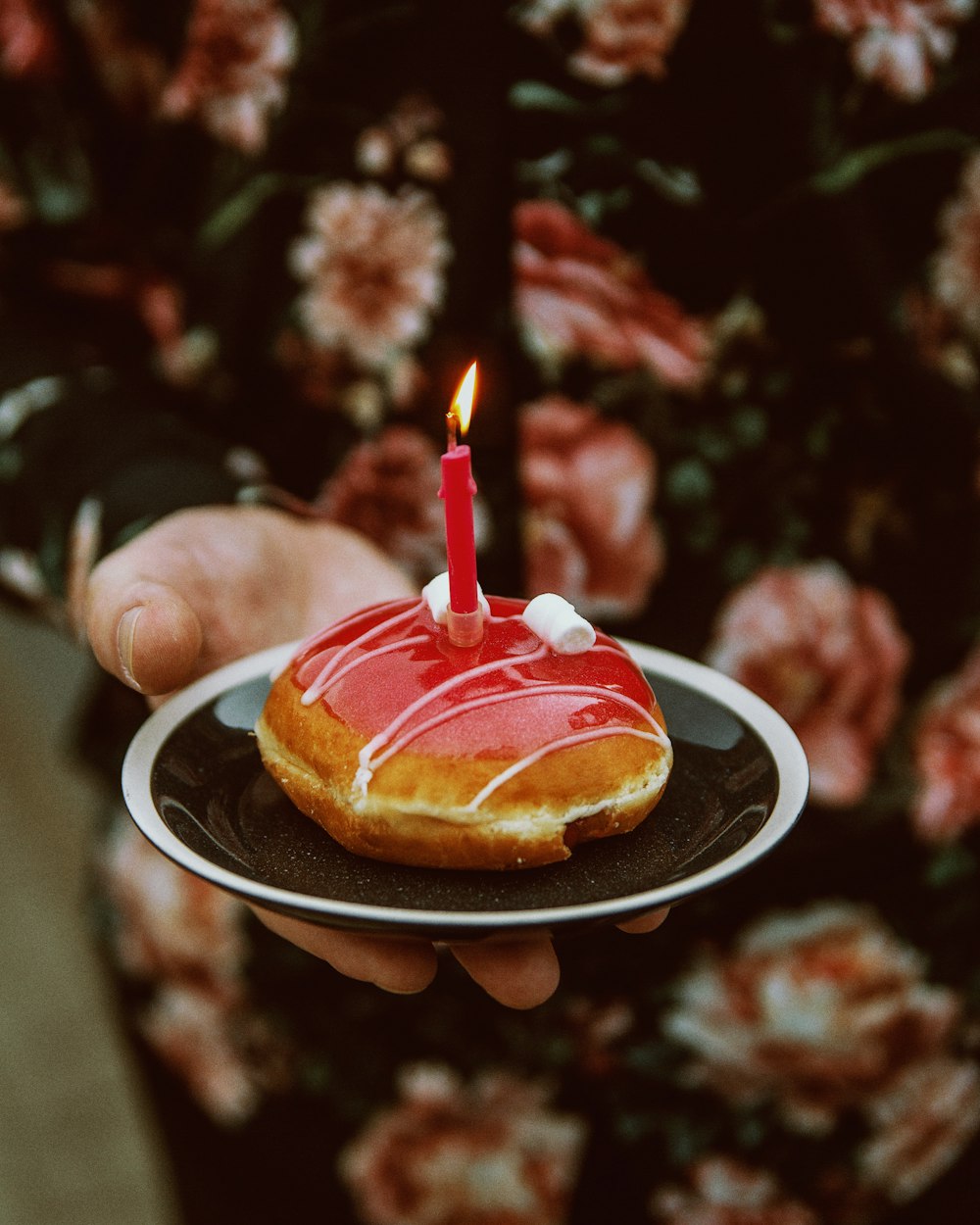 person holding bread with red candle