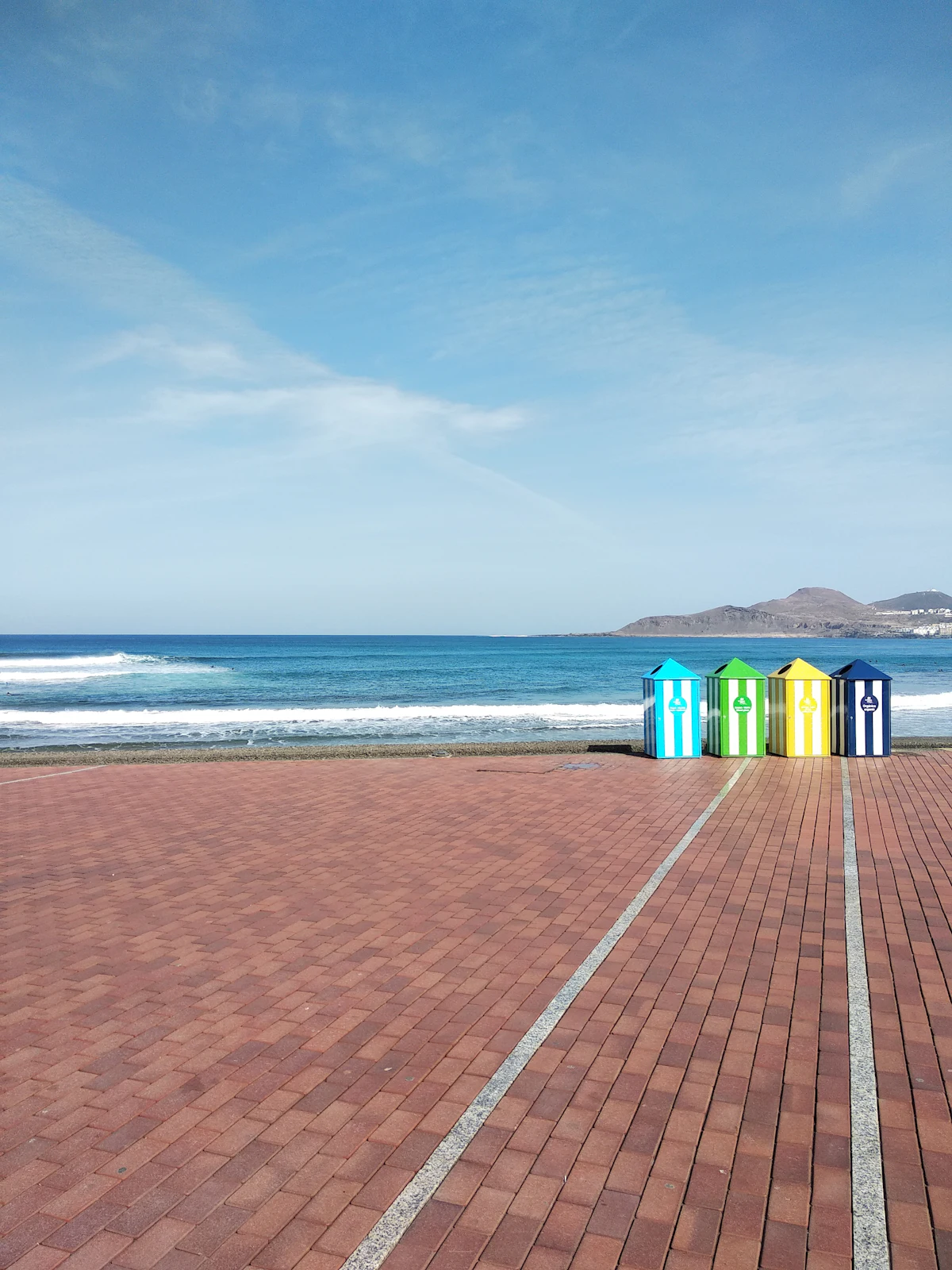 The brick promenade at Las Canteras beach in Las Palmas, with colorful beach huts and the sea