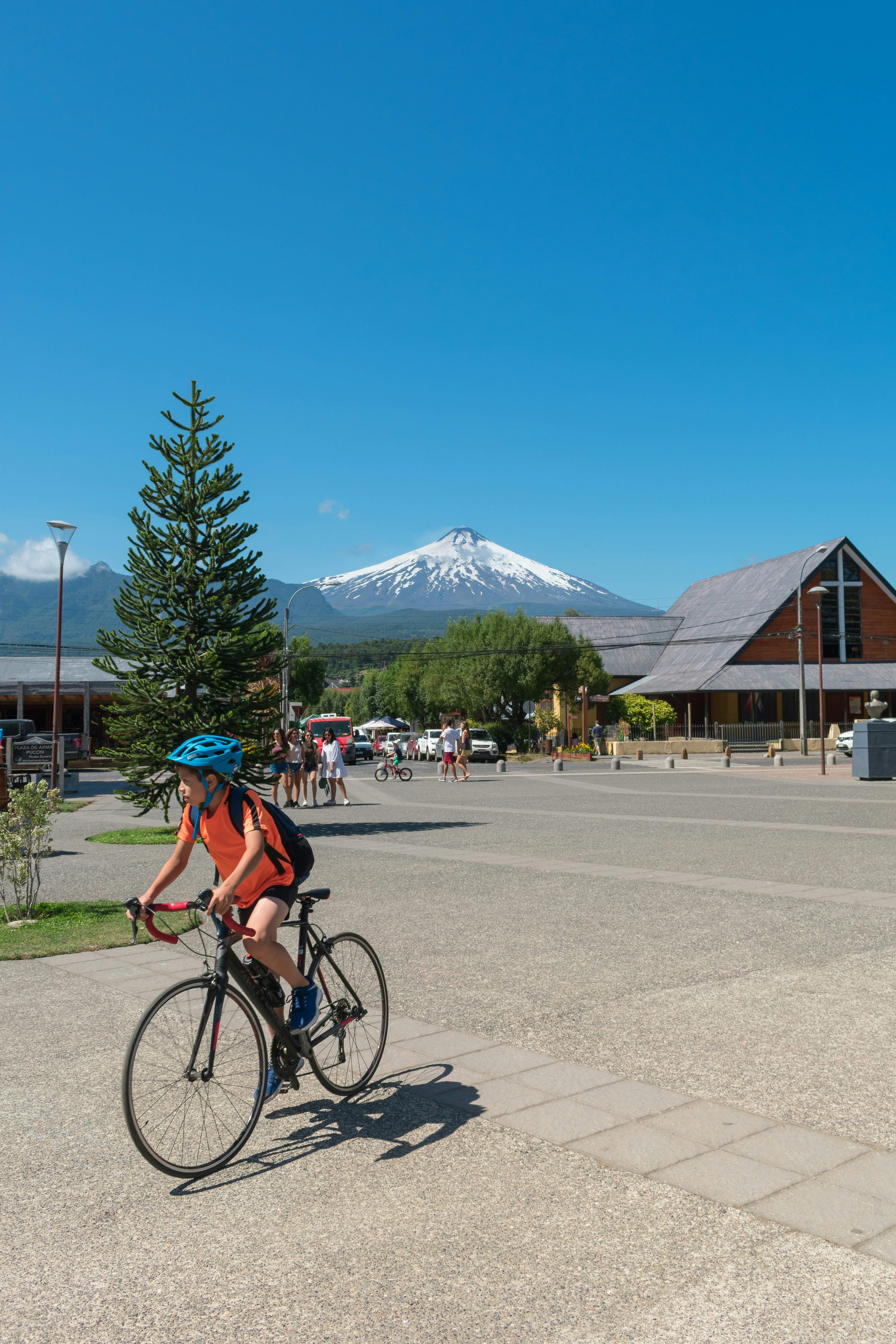 man in orange shirt riding bicycle on road during daytime