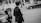 Monochrome image of a stylish man with urban 90s Los Angeles inspired fashion standing in a city street