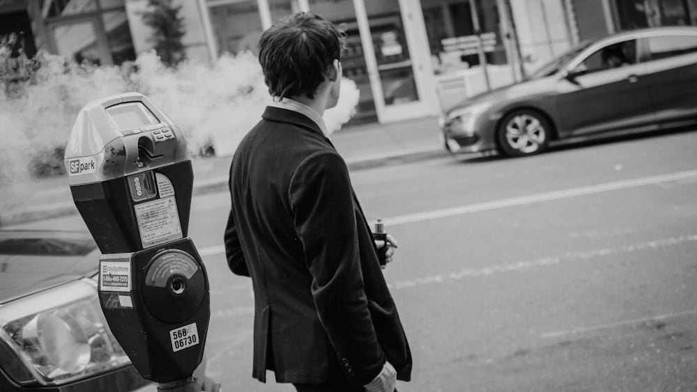 man in black jacket standing on road