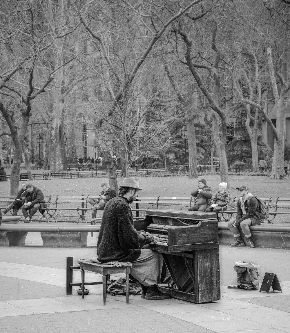 grayscale photo of people sitting on bench