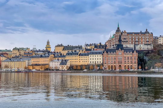 brown and white concrete building near body of water during daytime in Stockholm Sweden