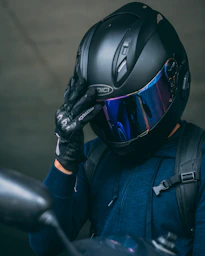 person in black helmet and blue jacket