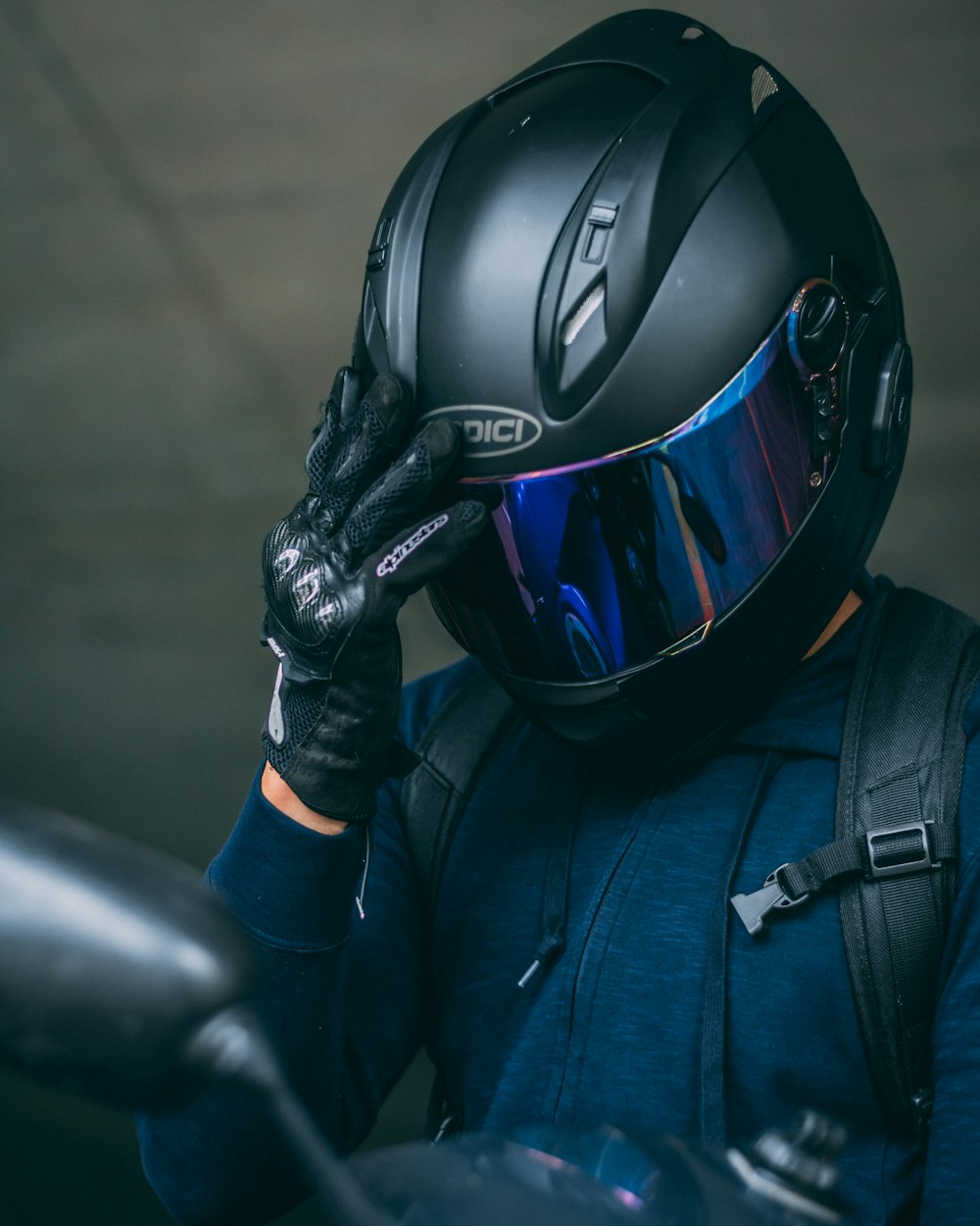 Person in schwarzem Helm und blauer Jacke